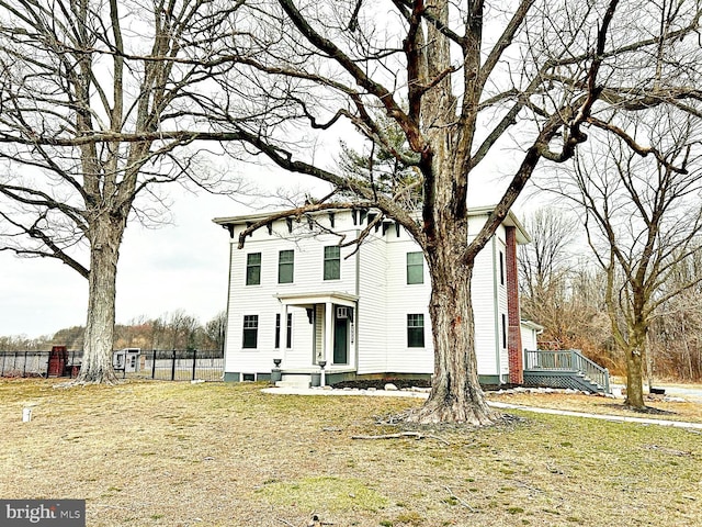 view of front of house featuring a chimney and fence