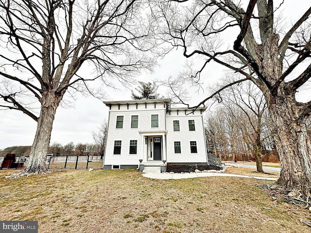 italianate house featuring a front yard and fence