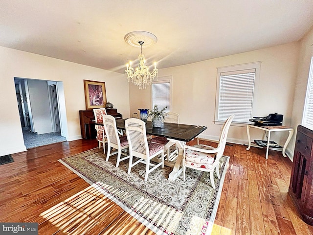 dining area with an inviting chandelier, baseboards, and wood finished floors