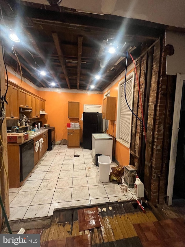 basement with light tile patterned flooring and black fridge