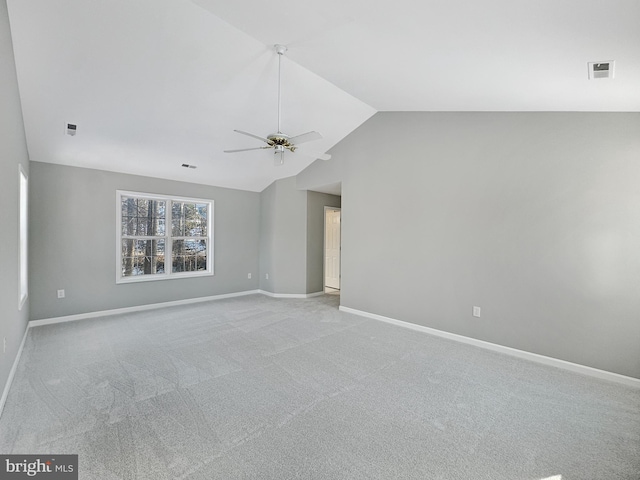 carpeted empty room featuring vaulted ceiling and ceiling fan