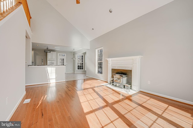 unfurnished living room with hardwood / wood-style flooring and high vaulted ceiling