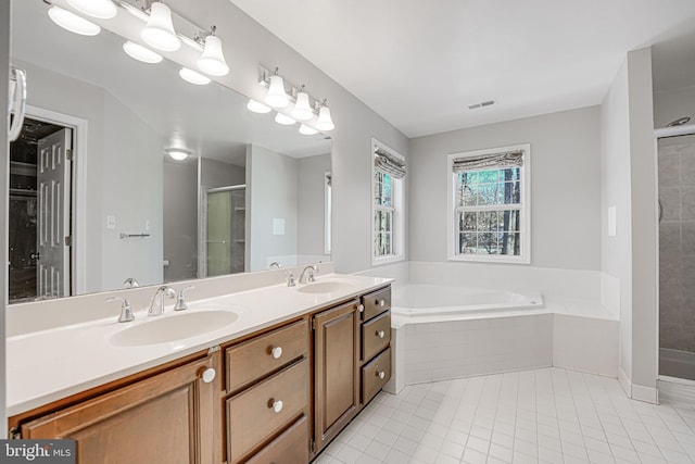 bathroom featuring tile patterned flooring, vanity, and shower with separate bathtub