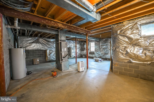 basement with heating unit, plenty of natural light, and water heater