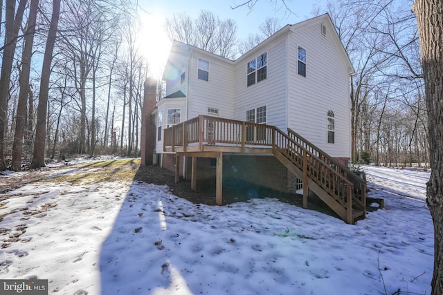 snow covered house featuring a deck