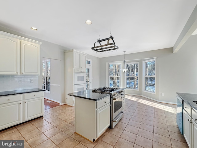 kitchen with white cabinetry, decorative light fixtures, and stainless steel appliances