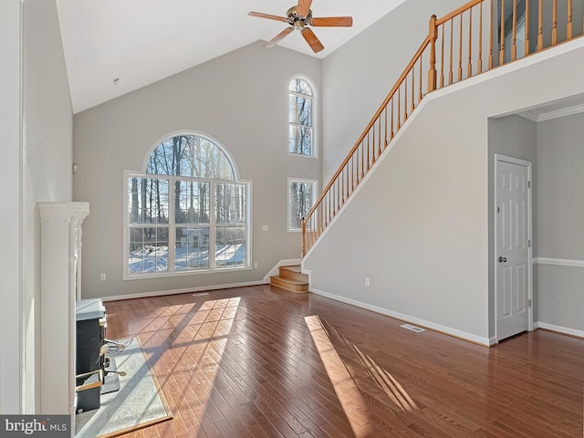 unfurnished living room with dark hardwood / wood-style flooring, high vaulted ceiling, and ceiling fan