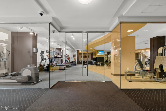 gym with rail lighting and carpet floors