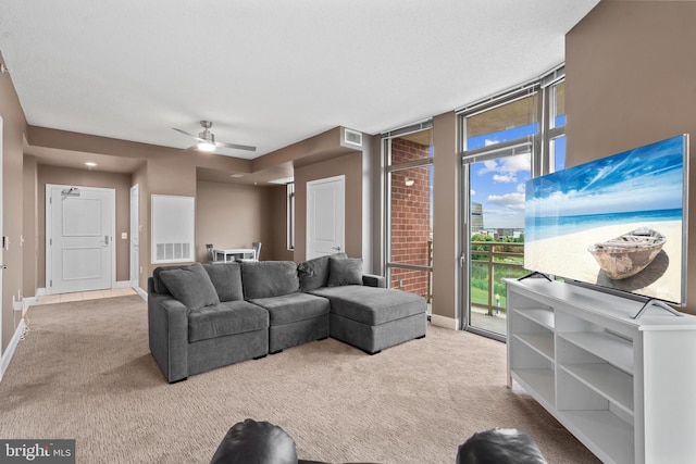 carpeted living room featuring expansive windows and ceiling fan