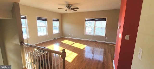 empty room featuring plenty of natural light, hardwood / wood-style floors, and ceiling fan