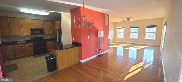 kitchen with hardwood / wood-style flooring, ceiling fan, hanging light fixtures, and black appliances