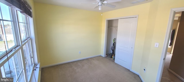 unfurnished bedroom featuring ceiling fan, a closet, and light carpet