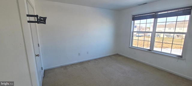 empty room with a wealth of natural light and light colored carpet