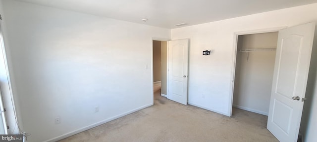 unfurnished bedroom with light carpet and a closet