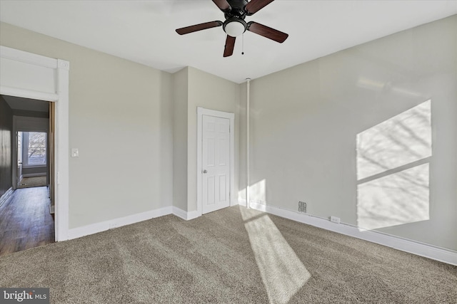 carpeted spare room featuring ceiling fan