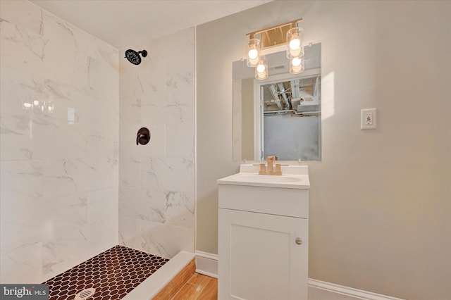 bathroom featuring vanity, hardwood / wood-style floors, and a tile shower