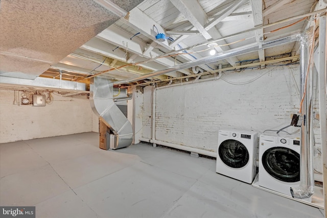 basement with heating unit, electric panel, and washing machine and clothes dryer