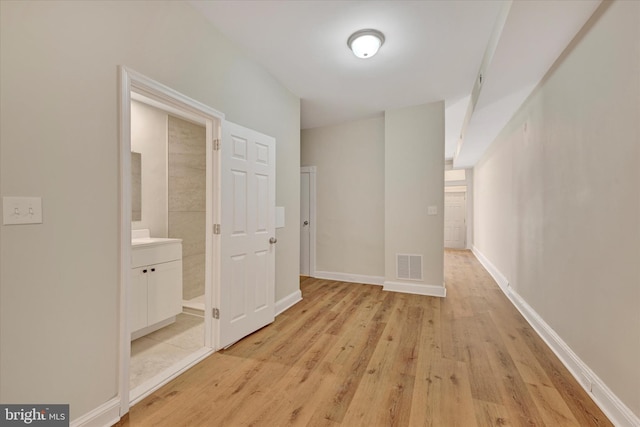 corridor with light hardwood / wood-style floors