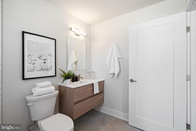 bathroom featuring vanity, tile patterned floors, and toilet