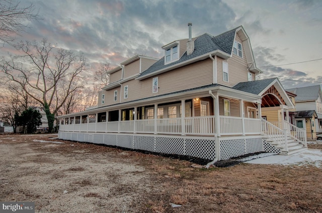 property exterior at dusk with covered porch