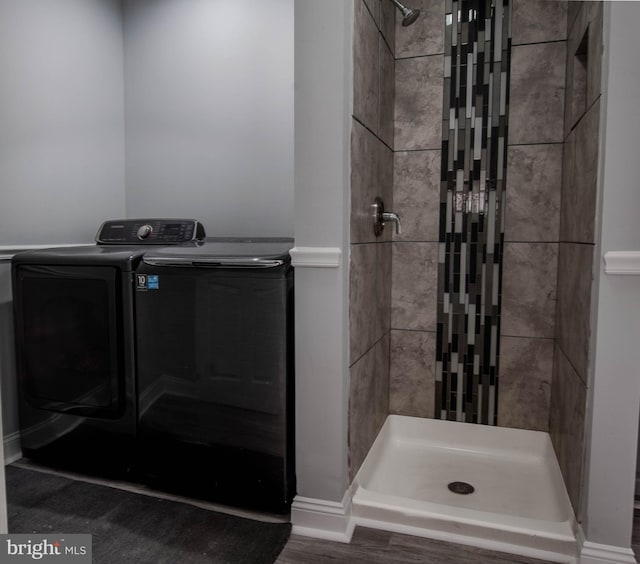 bathroom with a tile shower and washer and clothes dryer