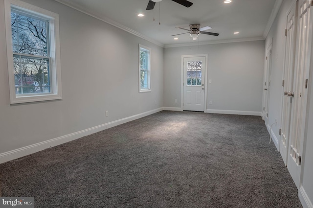 unfurnished room with crown molding and dark colored carpet