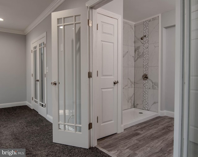 bathroom featuring a tile shower, hardwood / wood-style flooring, and ornamental molding