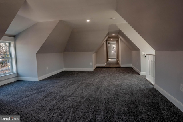 bonus room featuring vaulted ceiling and dark colored carpet