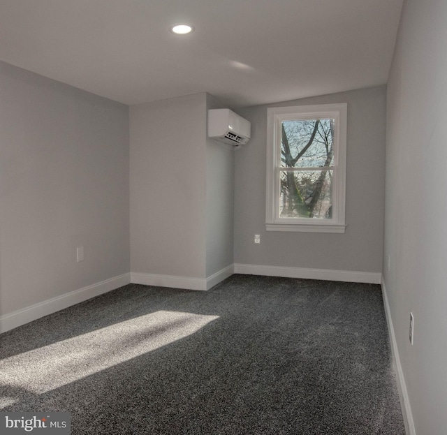 spare room with a wall mounted AC and dark colored carpet