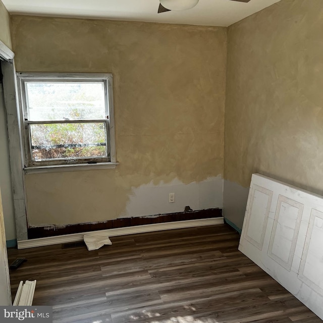 spare room featuring dark wood-type flooring and ceiling fan