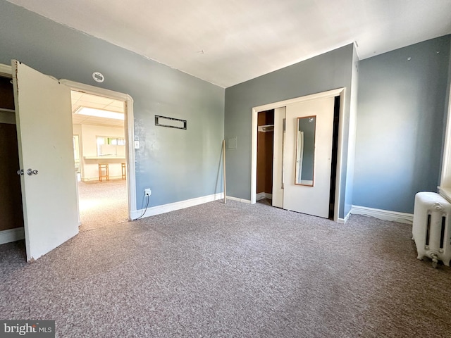 unfurnished bedroom with carpet floors and radiator heating unit