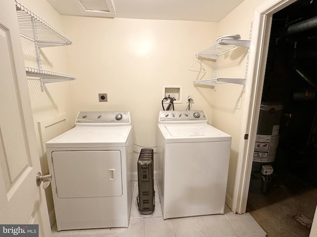 laundry room with light tile patterned flooring, gas water heater, and washing machine and clothes dryer