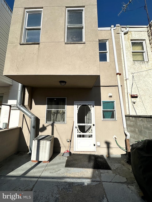 property entrance featuring a patio and central air condition unit