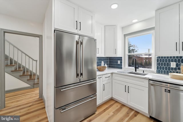 kitchen featuring stainless steel appliances, sink, and white cabinets