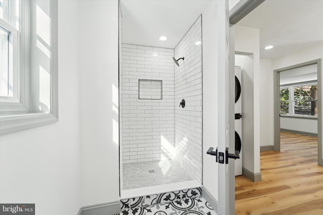 bathroom with tiled shower and wood-type flooring