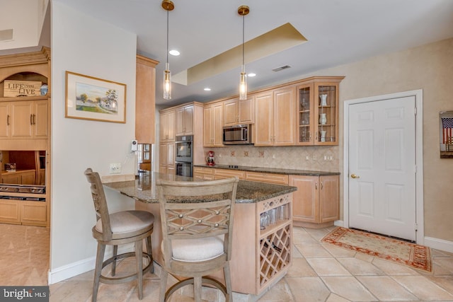 kitchen with hanging light fixtures, dark stone countertops, a kitchen breakfast bar, kitchen peninsula, and black appliances