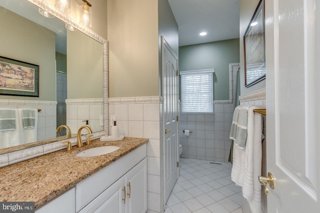 bathroom featuring vanity, tile walls, tile patterned floors, and toilet