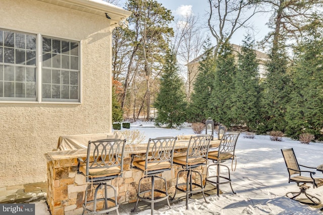 snow covered patio featuring an outdoor bar