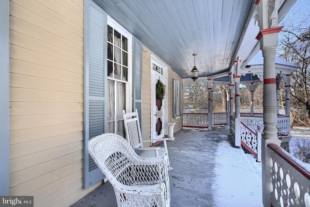 snow covered patio with a porch