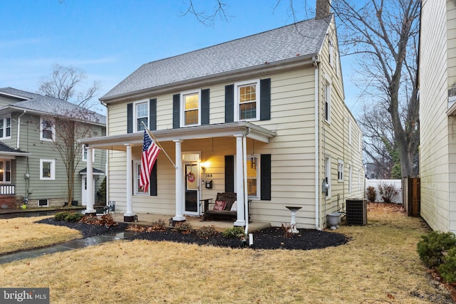 view of front facade featuring central AC unit, a front lawn, and a porch