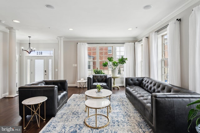 living room with crown molding, a wealth of natural light, dark wood-type flooring, and ornate columns