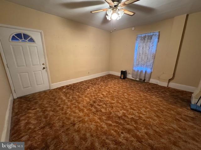 carpeted spare room featuring ceiling fan