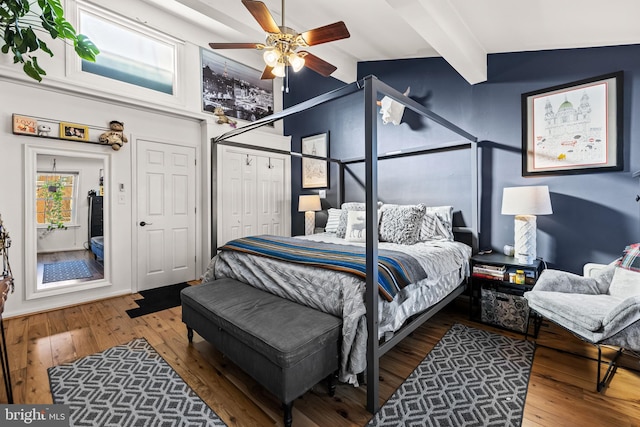 bedroom with hardwood / wood-style flooring, ceiling fan, and beam ceiling