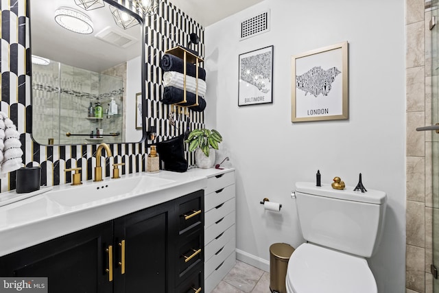 bathroom with a shower with door, vanity, and toilet