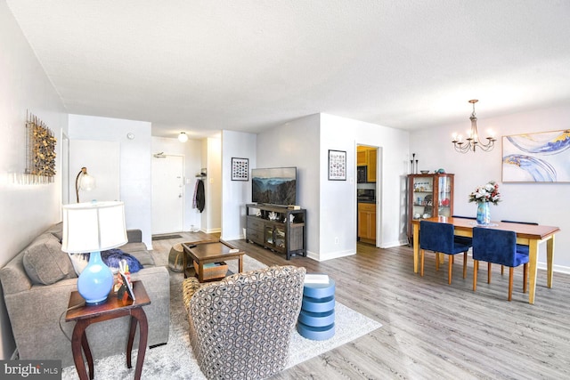 living room with wood-type flooring, a chandelier, and a textured ceiling