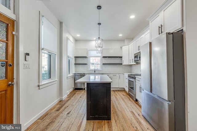 kitchen featuring white cabinetry, tasteful backsplash, a center island, pendant lighting, and stainless steel appliances