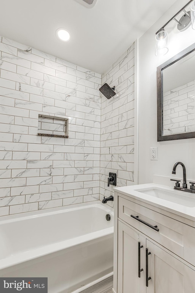 bathroom with vanity and tiled shower / bath combo