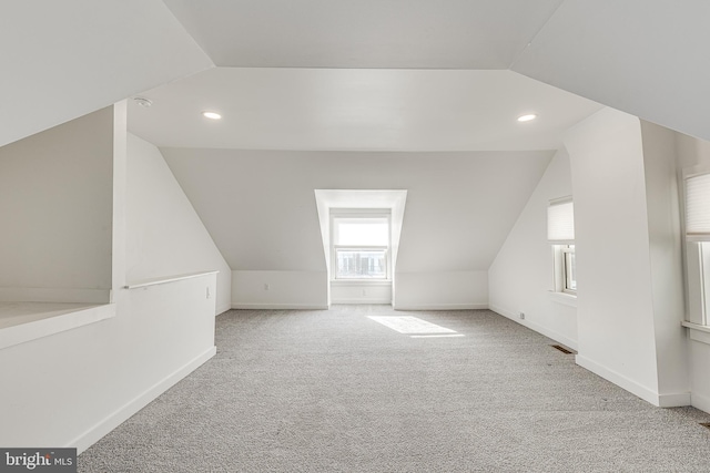 bonus room featuring lofted ceiling and light carpet