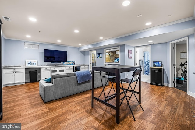 living room featuring crown molding, beverage cooler, and light hardwood / wood-style floors