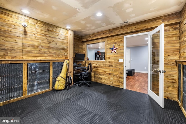 workout area featuring french doors, carpet flooring, and wood walls